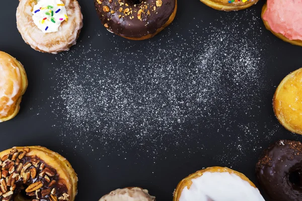 Diverse donuts med pulver mjöl — Stockfoto