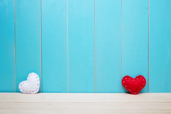 Ручное изготовление войлочных сердец на синем фоне — стоковое фото