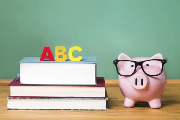 Thème scolaire avec ABCs et tirelire rose avec tableau noir — Photo