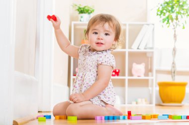 Onun oyuncak bloklarla oynama yürümeye başlayan çocuk kız