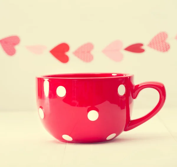 Grande tasse de café rouge et guirlande de coeurs — Photo