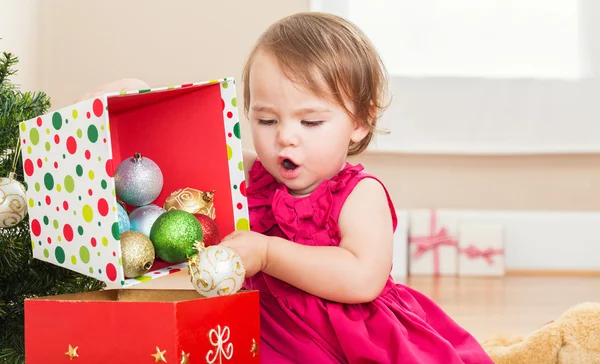 Kleines Mädchen spielt mit Weihnachtsdekoration — Stockfoto