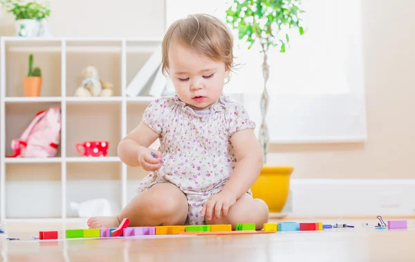 Menina da criança jogando seus brinquedos — Fotografia de Stock