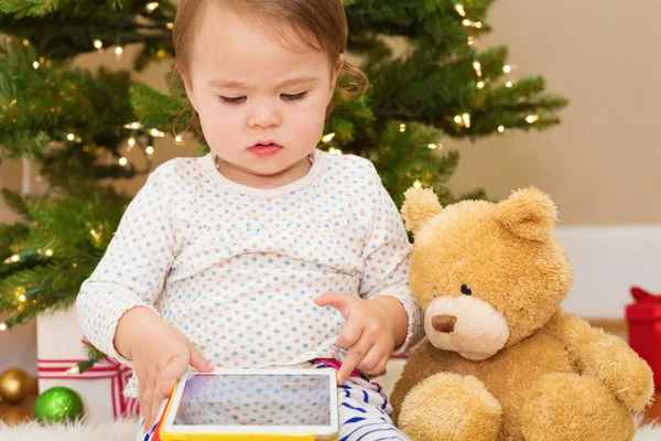 Meisje met behulp van haar tablet-pc in de buurt van de kerstboom — Stockfoto