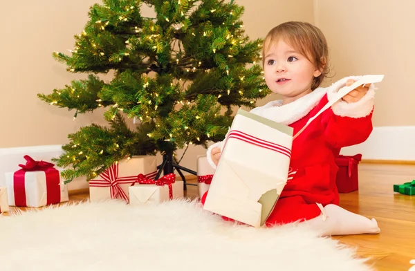 Meisje van de peuter openen Kerst presenteert — Stockfoto