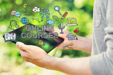 Online Courses concepts with man holding his tablet computer clipart