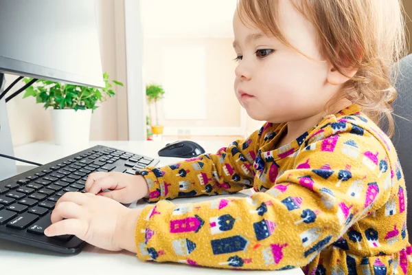 Peuter meisje typen op haar computertoetsenbord — Stockfoto