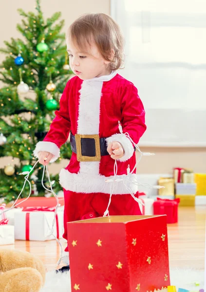 Peuter meisje spelen door de kerstboom — Stockfoto