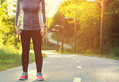 Kadın atlet orman yolu üzerinde bir dürtmek için hazırlanıyor