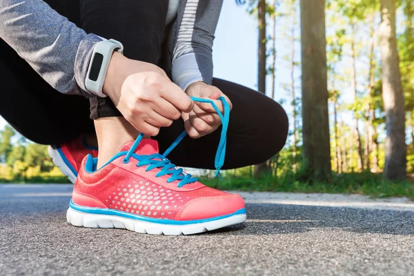 Kvinnliga jogger knyta hennes skor — Stockfoto