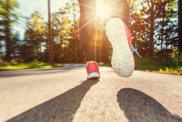 Läuferin joggt die Straße hinunter — Stockfoto