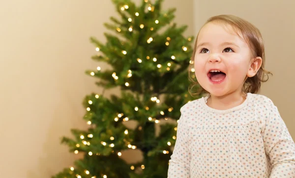 Fille joyeuse souriant devant le sapin de Noël — Photo