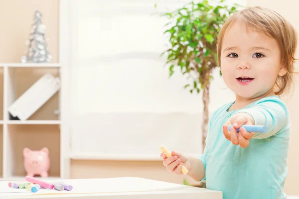 Happy toddler girl playing with chalk — Stock Photo, Image