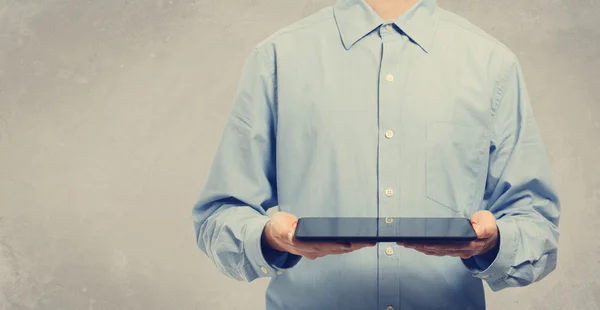 Junger Mann hält Tablet-Computer in der Hand — Stockfoto