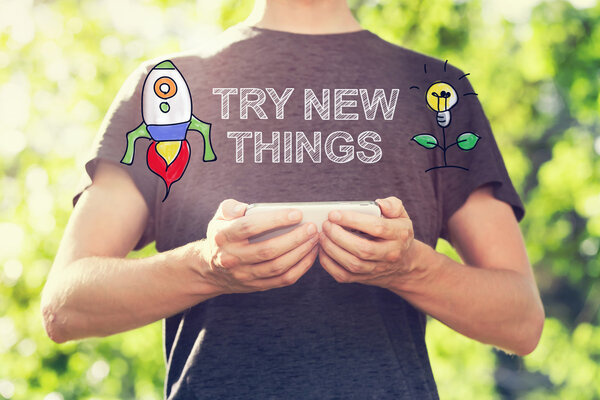 Try New Things concept with man holding his smartphone