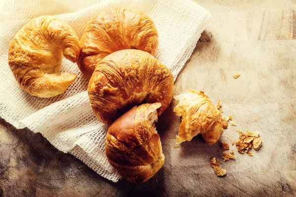 Batch van croissants op een rustieke tafel — Stockfoto