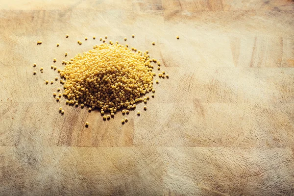 Millet em uma mesa rústica de madeira — Fotografia de Stock