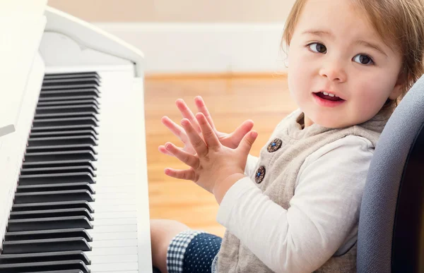 Happy toddler girl playing piano — Stock Photo, Image