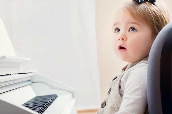 Toddler girl in front of a piano — Stock Photo, Image