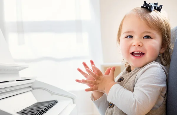 Feliz niña sonriente emocionada por tocar el piano — Foto de Stock