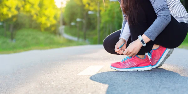 Joggerin schnürt ihre Schuhe — Stockfoto