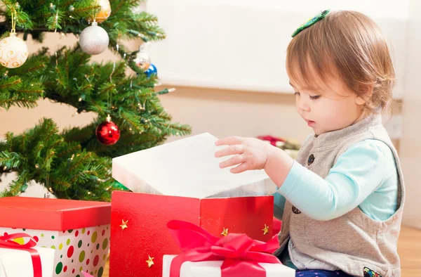 Peuter meisje openen een kerstcadeau — Stockfoto