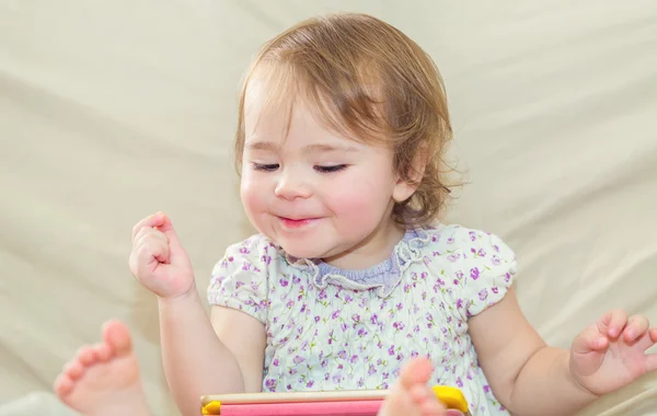 Menina criança feliz brincando com seu computador tablet — Fotografia de Stock