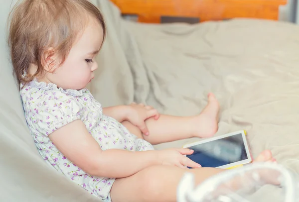 Barn tjej tittar på hennes tablet PC — Stockfoto