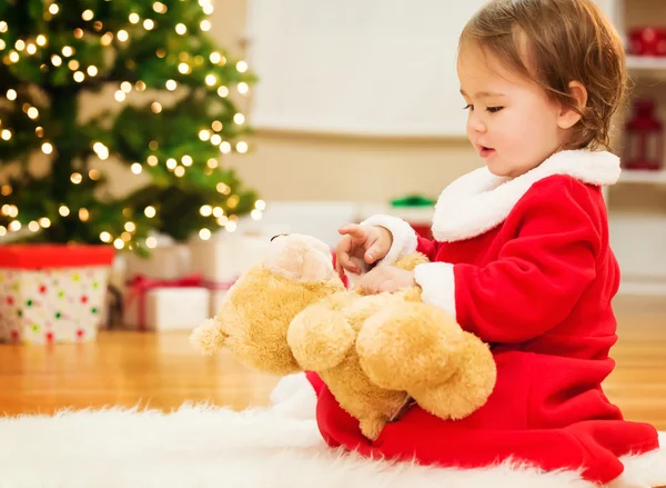 Κορίτσι μικρό παιδί που παίζει με το αρκουδάκι για τα Χριστούγεννα — Φωτογραφία Αρχείου