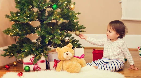 Toddler girl playing by the Christmas tree — Stock Photo, Image