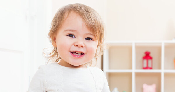 Happy toddler smiling in her house