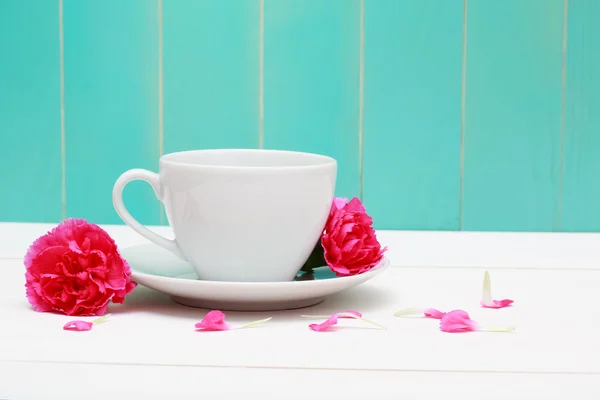 Coffee cup with pink carnations — Stock Photo, Image