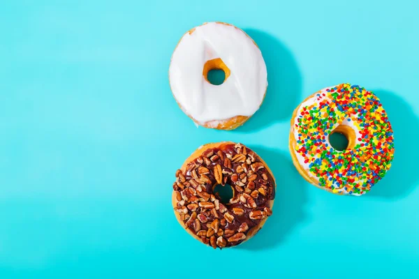 Donuts assortis sur fond bleu pastel — Photo