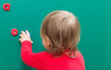 Bir kara tahta üzerinde onun Abcs öğrenme yürümeye başlayan çocuk kız