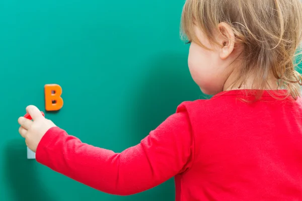 Toddler dziewczynka nauki jej ABC na tablicy szkolnej — Zdjęcie stockowe