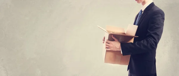 Empresário segurando uma caixa de papelão — Fotografia de Stock