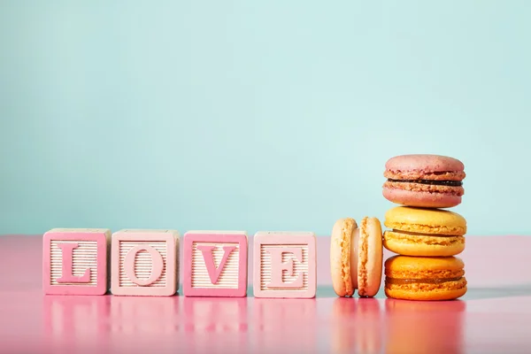 Macarons with LOVE message on wooden blocks — Stock Photo, Image