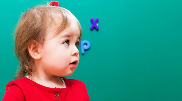 Toddler dziewczynka z przodu zielona tablica — Zdjęcie stockowe