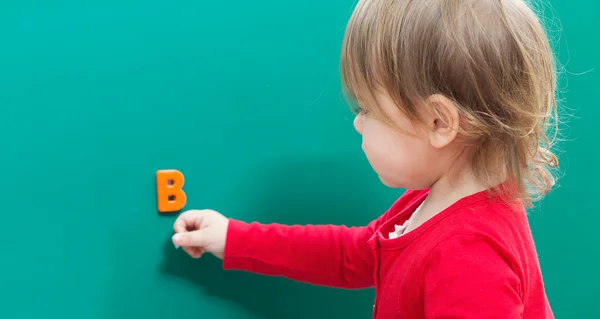 Batole dívka učí její ABC na tabuli — Stock fotografie