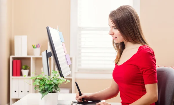 Gelukkig jonge vrouw die werkt in haar kantoor aan huis — Stockfoto