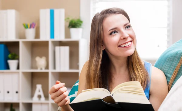 Счастливая молодая женщина, читающая книгу — стоковое фото