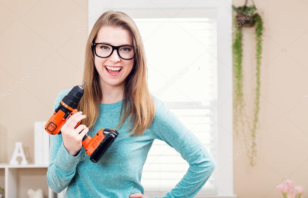 Young woman with cordless drill 