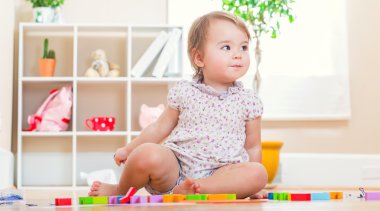 Onun oyuncakları ile oynarken yürümeye başlayan çocuk kız 