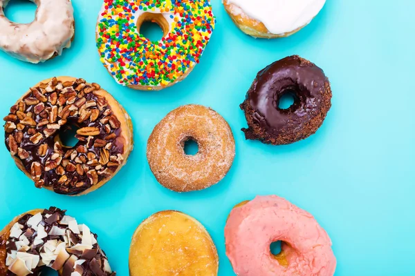 Geassorteerde donuts op pastel blauwe achtergrond — Stockfoto