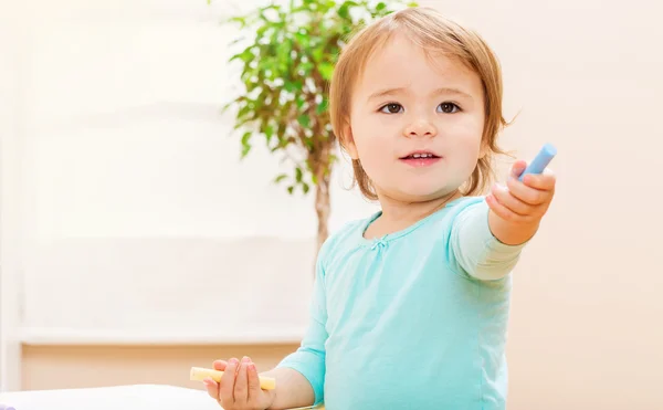 Happy toddler girl playing with chalks — Stock Photo, Image