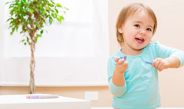 Glada barnet flicka som leker med kritor — Stockfoto