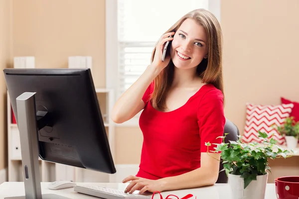 Mujer joven y feliz hablando por teléfono en su oficina — Foto de Stock