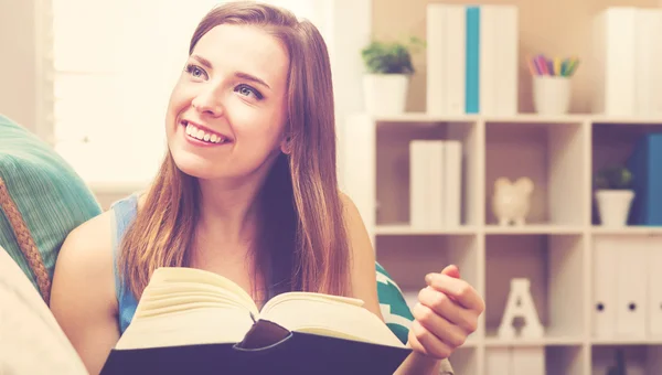 Gelukkig jonge vrouw lezen van een boek — Stockfoto