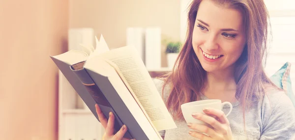 Glückliche junge Frau liest ein Buch — Stockfoto