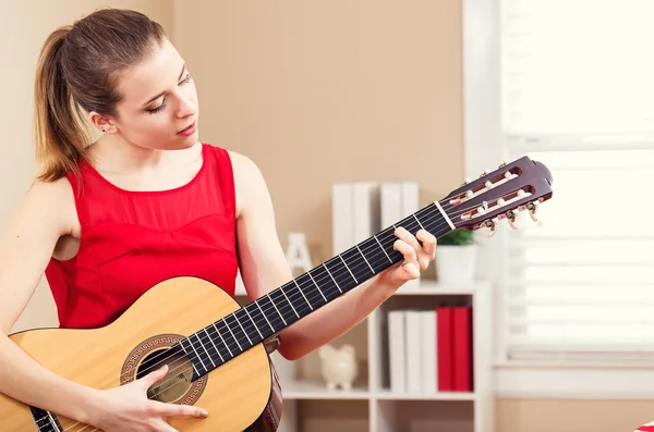 Mladá žena hrající na kytaru — Stock fotografie